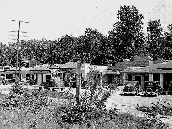 buildings in a row along Route 66 black and white photo with 1930s cars