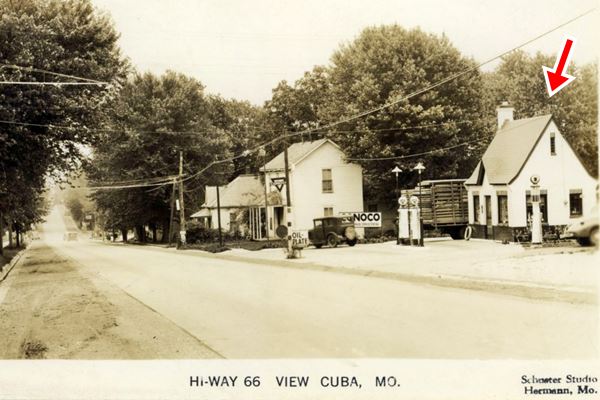 1930s view of Route 66, sepia colored, with car, home and cottage style Conoco station with pumps