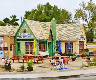 Former Phillips 66 station Cuba MO gable roofed building, 1 story with chimney, former gas station on a corner, tables. It is a cafek