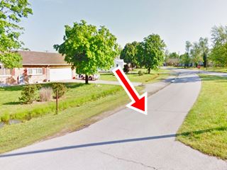 curved concrete paved roadbed in urban setting, with houses