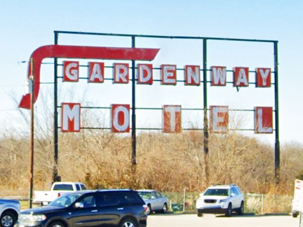 neon sign with red arrow and words "Gardenway Motel" in white letters on red squares standing high above cars Route 66 in Gray Summit Missouri