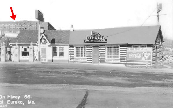 log cabin style cafe and cottage style gas station to the right, Route 66 in front black and white 1950s photo