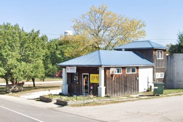 color photo hipped roof building on the corner of US66 in 2021