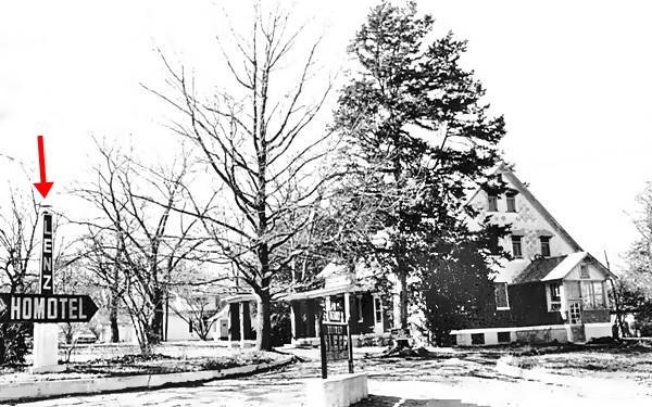 black and white photo ca.1930s of the old house, garden trees and its sign