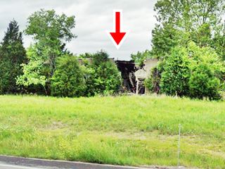 Lowery’ gas station and Garbage Can cafe ruins on Route 66 trees surround ruins of a decaying building by exit ramp of I-44
