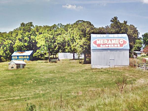 Barns with Meramec Caverns advertisments painted on their roof and walls