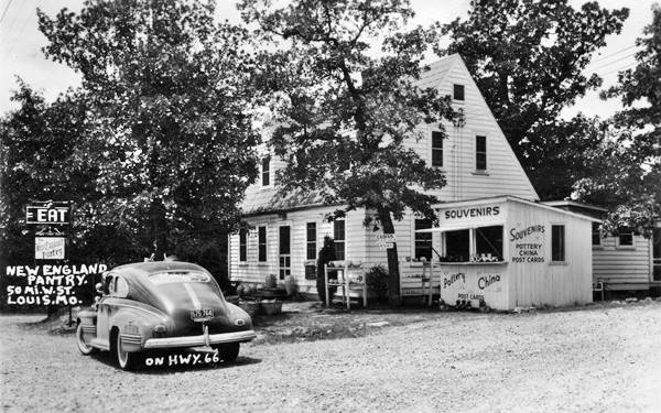 gable roof two-story building and vintage car in 1940s postcard