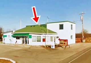 hipped roof gas station and store next to 2 story building and US66