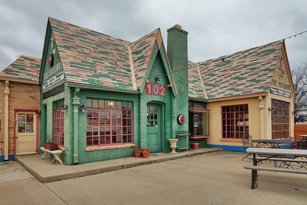 cross gable brick cottage-style gas station with chimney