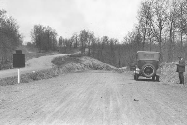 black and white 1920s photo of the fork between US66 and MO-28, man and car