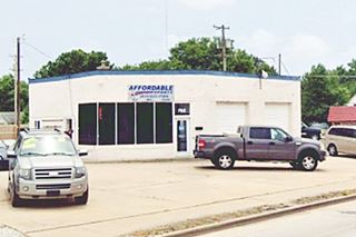 former gas station with angled corner office and cars parked