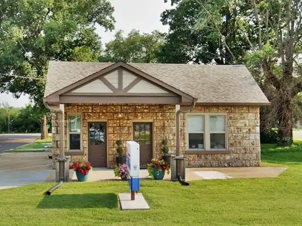 gable roof, gable canopy, stone block home-like gas station, lawn, trees