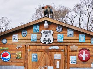 Missouri Hick Barbeque, pig on rooftop detail from photo by Carol M. Highsmith large pig statue on gable ridge. Facade covered with enamel signs