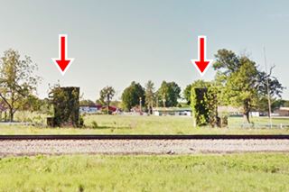 stone columns at Ranch Hotel two stone pillars in a field behind railroad tracks