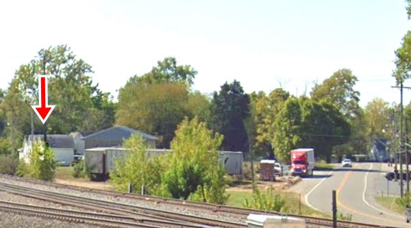 looking west along Route 66. Cabins at the back of a lot, US 66 to the right