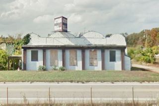 old vacant building, boarded windows by Route 66