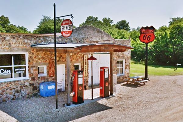 rock faced gas station building, with vintage gas pumps