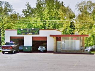 1950s Phillips 66 station with rock wall, plate glass, two bay garages