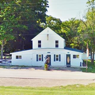 white gable roof two story building among trees