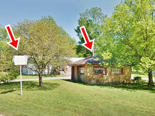 stone building hipped roof and old neon sign of a drive in theater among the trees