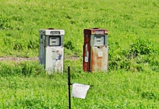 2 1950s gas pumps in a field