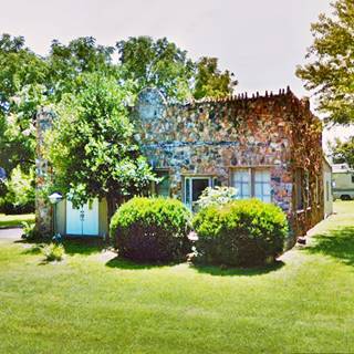 rock faced building surrounded by lawn and trees