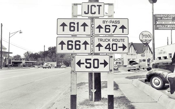 black and white 1950s photo of US highway road signs at a junction