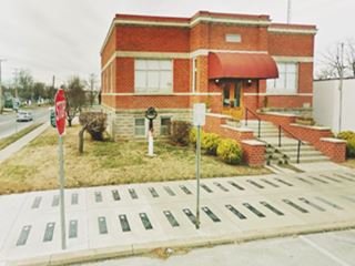 black rectangles with a star and a name painted on sidewalk