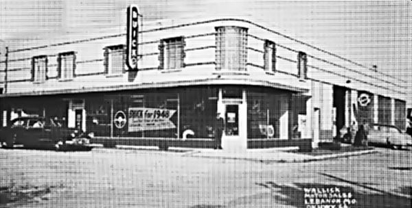building on a corner, black and white photo 1948, vintage cars