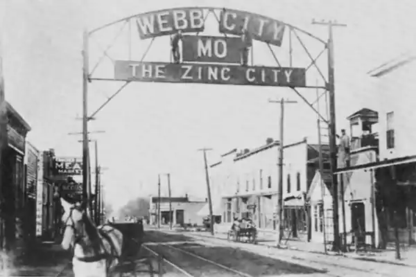 vintage b-and-w photo: steel arch across street