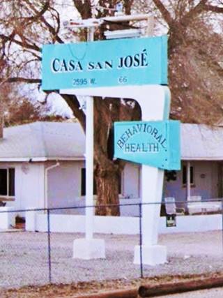 Pale blue and white 1950s neon sign: steel pole to the left, angled and curved main support to the right. Two panels