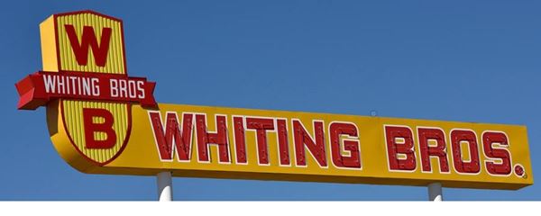 Whiting Brothers sign on US66 Moriarty NM Yellow sign red letters spelling: WHITING BROS, and a shield on its tip with letters W and B