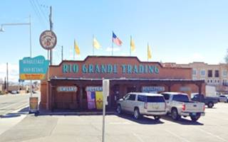 former Shamrock station Pueblo style building, a trading Post with cars parked and verandah