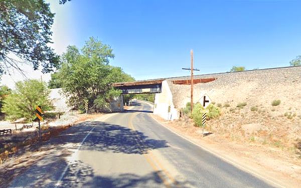 color, former Route 66 and current 85 curves beneath the tracks using an underpass, trees by the hwy.