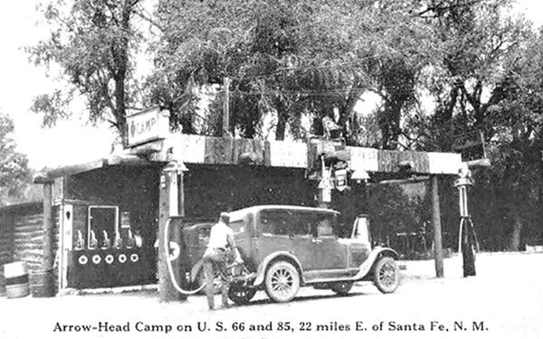 Arrowhead Camp filling station 1920s black and white c.1920s log built flat canopy gas station, trees, 3 pumps, trees behind