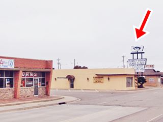 building on corner and neon sign