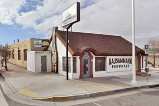 color view of a side street and sign on the left, Route 66 in front and cottage facing it