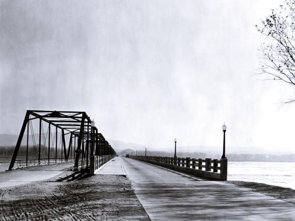 two bridges side by side, left steel with girders and superstructure, right: low concrete one, Rio Grande runs left to right