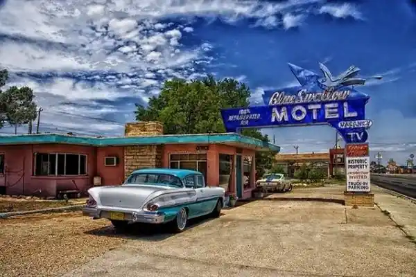 Old car, office and 1950s neon sign at the Blue Swallow Motel