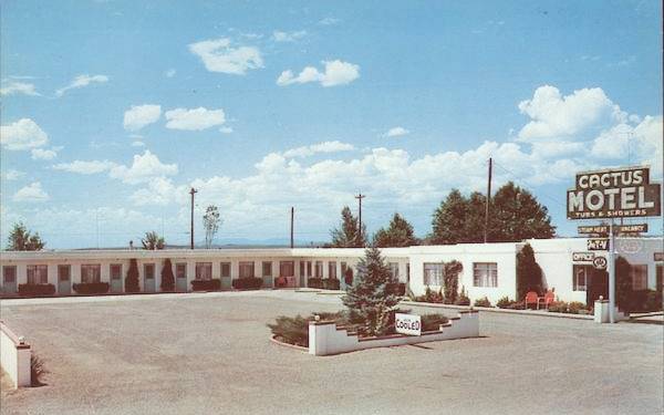 color 1960s postcard: L shaped motel with neon sign