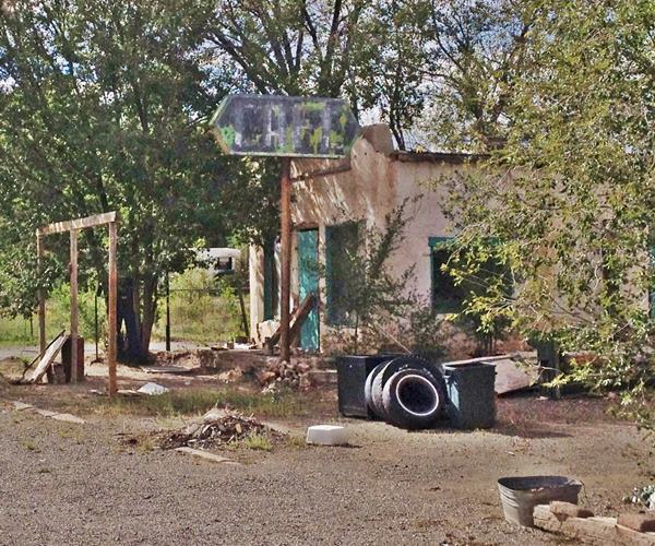 Cafe and neon sign San Fidel US66 Cafe, faded sign, trees around it, abandoned