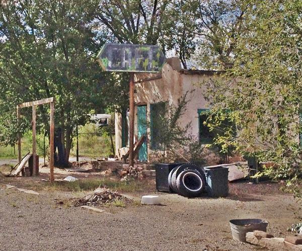 Cafe, faded sign, trees around it, abandoned