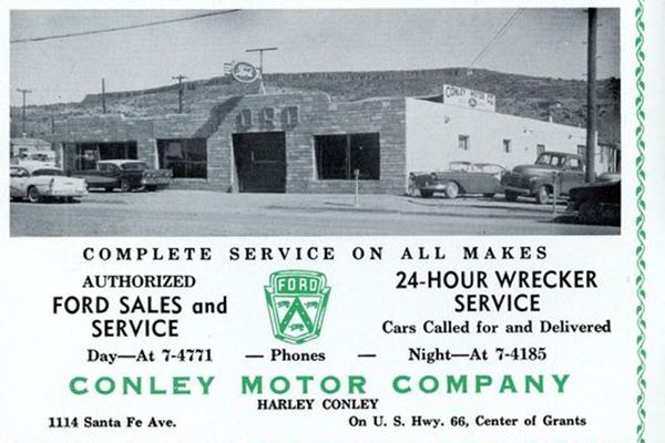1958 advertisement in black and green. Image shows a car dealership with Spanish Mission style building, cars and below text abut the business