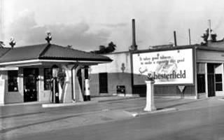 black and white photo 1940s of a hipped roof Conoco Station Route 66 runs in front left to right