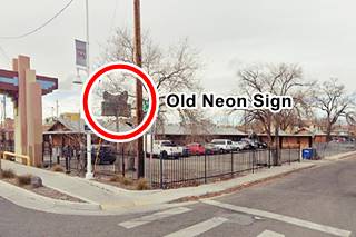 neon sign, faded with a prairie schooner depicted on it on a corner by a former motel