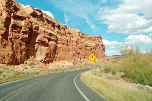 A sharp curve next to steep red cliffs on Route 66 in New Mexico