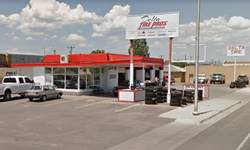Delta Tire in 2016 red and white flat canopy, glazed corner office, 4 service bay 1960s former gas station
