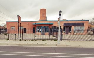 Durand Motor Co. nowadays US66 ABQ red-ochre block building, single floor, windows and central entrance under a rounded tower, steel fence around it a former gas station