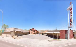 U-layout motel, white and red neon sign to the right, cottage 2 story gable roof office in the back, US66 in front