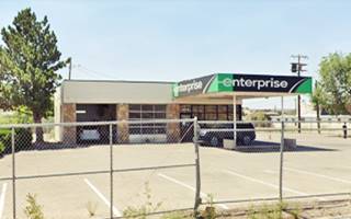 two service bays left, office right, flat roof, flat canopy 1960s gas station, stone walls